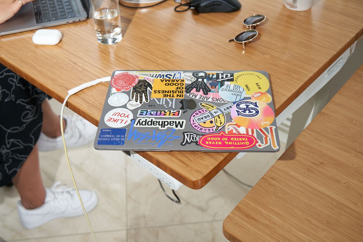 A heavily stickered laptop on one of the communal desk areas.