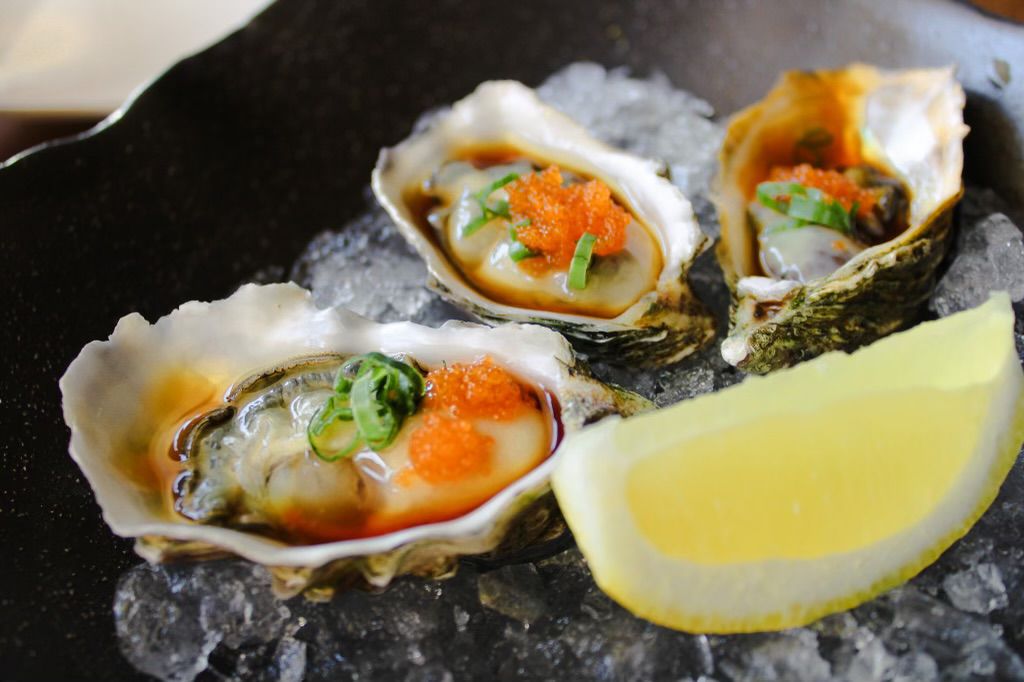 Raw oysters served with a lemon wedge.