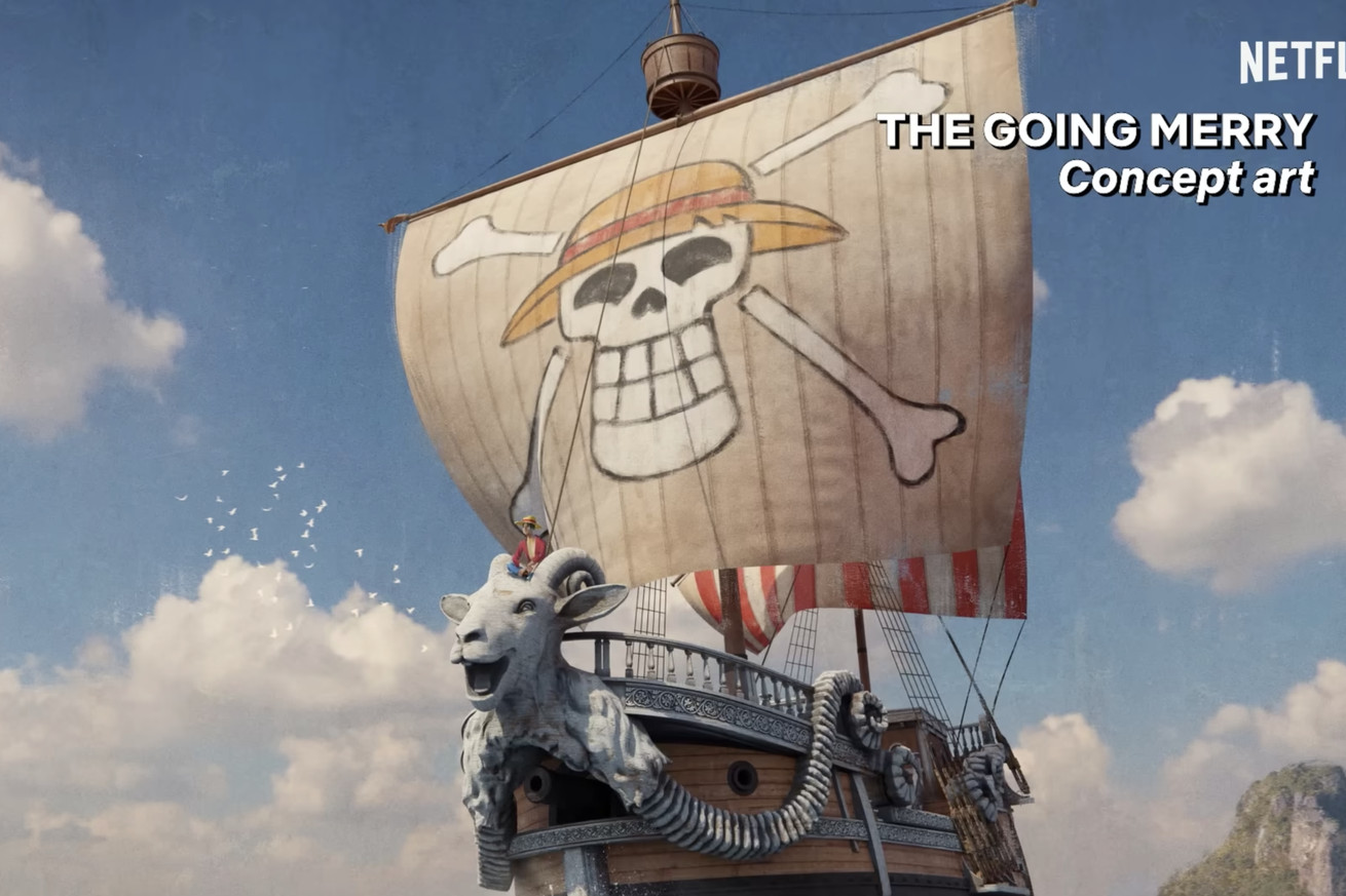 a 3⁄4 painting of a wooden ship with a massive sail emblazoned with a grinning skull wearing a hat.