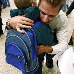 John McBride of Murray hugs 6-year-old orphan Ivan Gizatulin at the airport. Ivan will be staying with McBride and his family. The 45 orphans are the latest guests of the Save A Child Foundation.