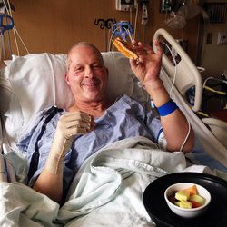 Richard Norby smiles as he eats food in the hospital after a bombing in Brussels, Belgium.