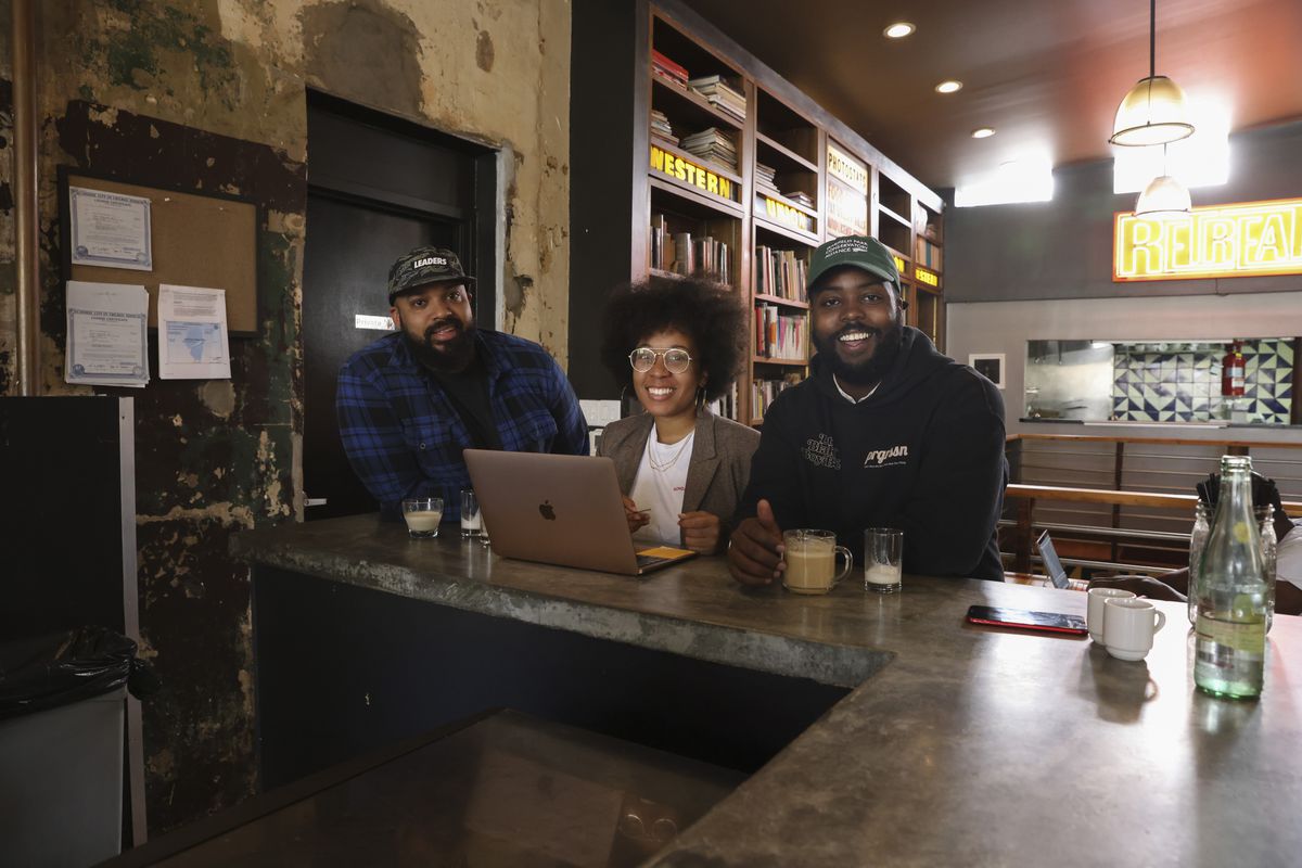 Tim Williams, founder of Pour Souls (from left), with Amanda Harth and Felton Kizer, founders of Monday Coffee Co., at Retreat Currency Exchange, 305 E. Garfield Blvd. in Washington Park.