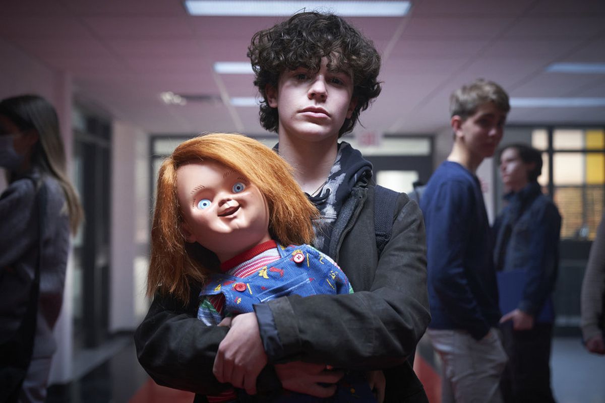 Zackary Arthur holds a beaming Chucky doll in Syfy/USA’s horror series Chucky