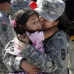 Returning soldier Papsy Lemus hugs her daughter, Nancy, at the airport Friday.