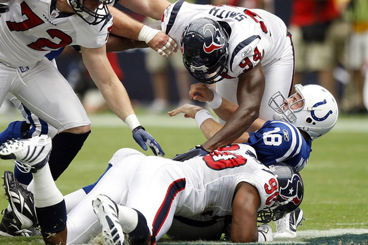 HOUSTON - SEPTEMBER 12:  Quarterback Peyton Manning #18 of the Indianapolis Colts is sacked by defensive ends Antonio Smith #94 and Mario Williams #90 at Reliant Stadium on September 12 2010 in Houston Texas.  (Photo by Bob Levey/Getty Images)