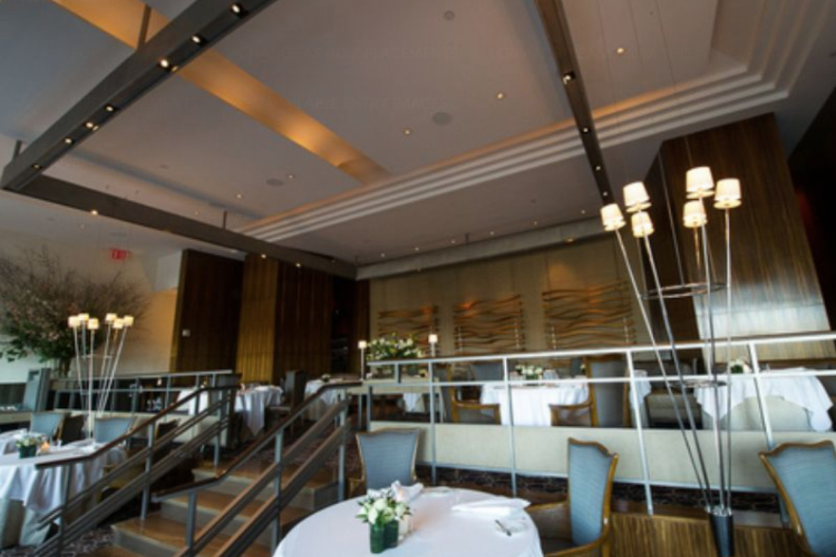 Tables with with tablecloths decorate the two-tiered dining room at Per Se