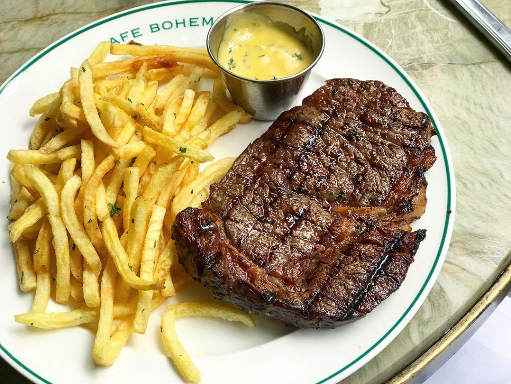 Steak frites on a white, monogrammed plate at Cafe Boheme, one of London’s best steak restaurants