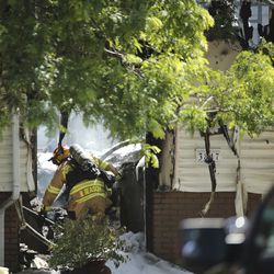 First responders work at the scene where an airplane crashed into houses in West Jordan on Saturday, July 25, 2020.