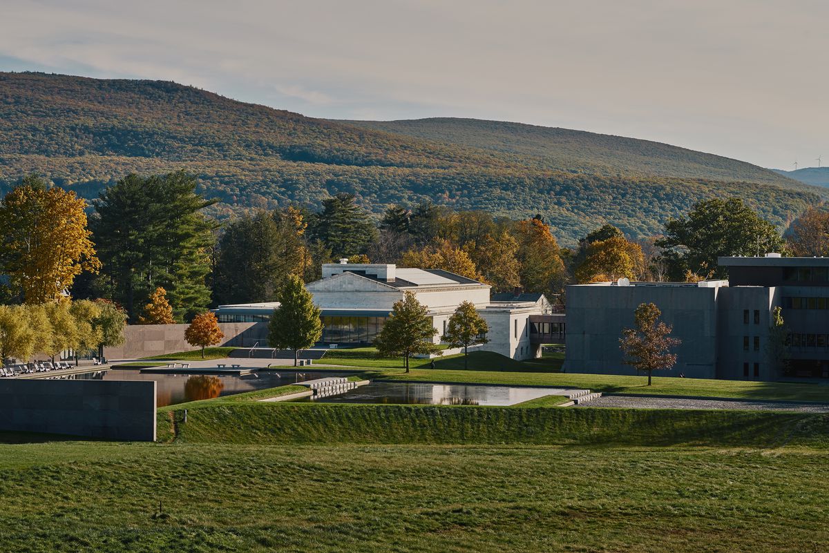 Several white and stone-gray buildings in a pastoral setting. 