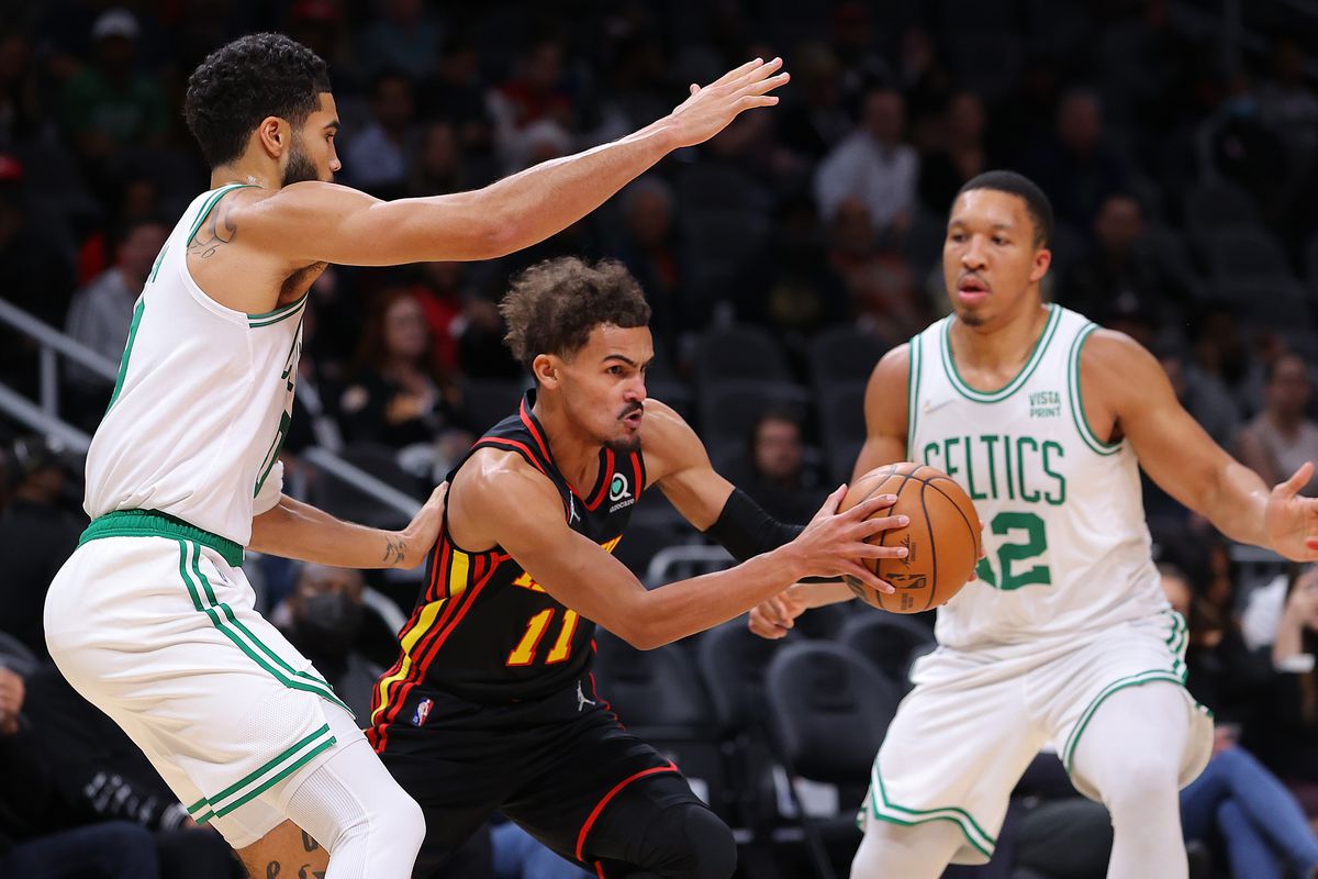 Trae Young #11 of the Atlanta Hawks drives against Jayson Tatum #0 and Grant Williams #12 of the Boston Celtics during the first half at State Farm Arena on November 17, 2021 in Atlanta, Georgia.&nbsp;