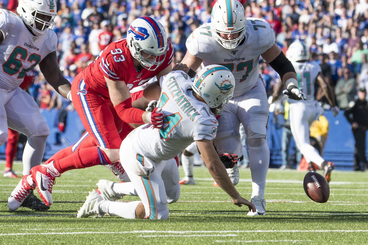 Miami Dolphins quarterback Ryan Fitzpatrick fumbles the ball as Buffalo Bills defensive end Trent Murphy and offensive guard Jesse Davis go for the ball in the fourth quarter at New Era Field.