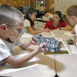 Landon Wanlass, left, and other students study items from the traveling Museum on the Move.
