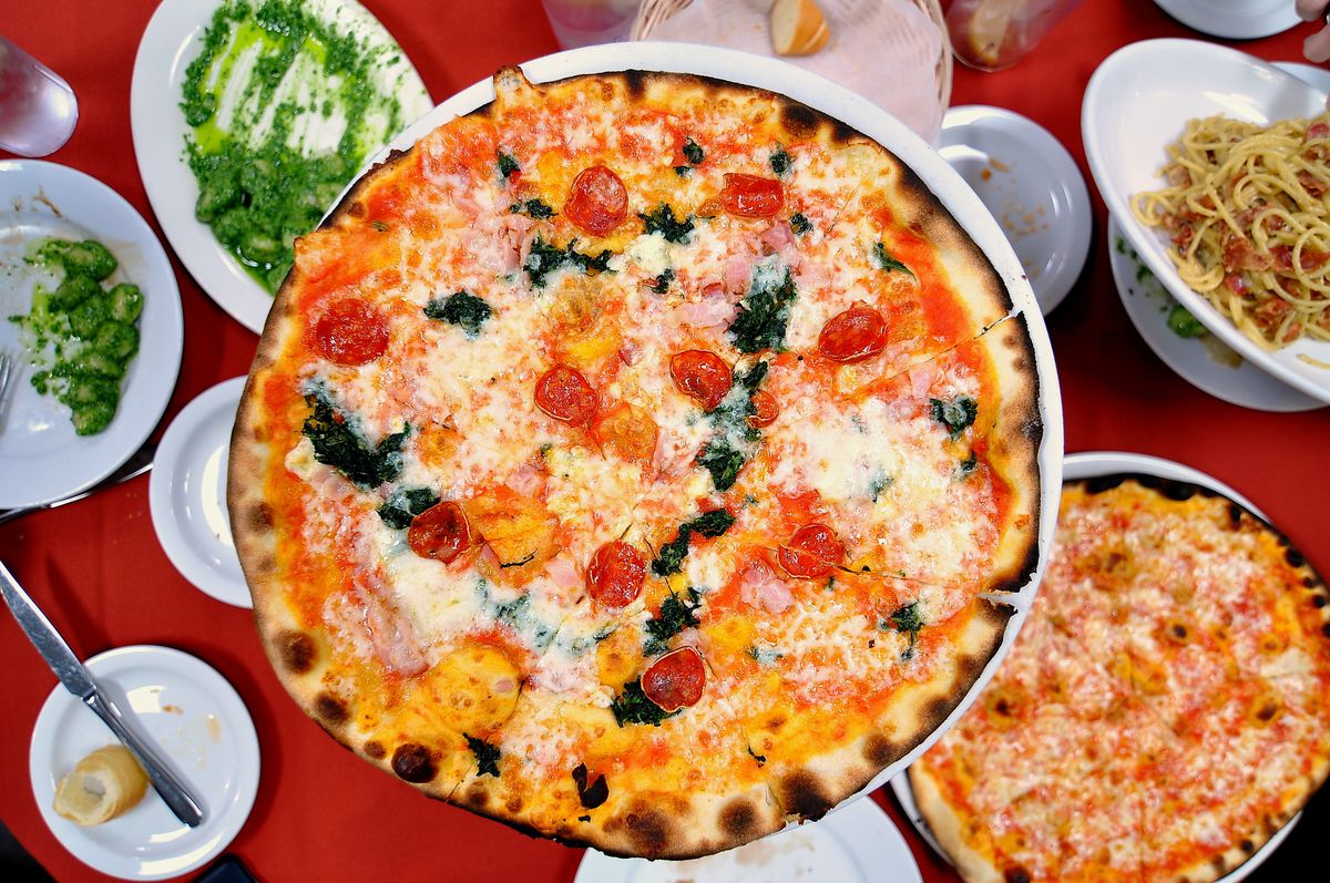 Overhead shot of pizza and other Italian dishes.