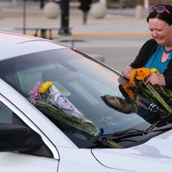 Tari Turner brings flowers to the patrol car of her nephew, West Valley police officer Cody Brotherson, outside the police station in West Valley City on Monday, Nov. 7, 2016. Brotherson was killed in the line of duty Sunday.
