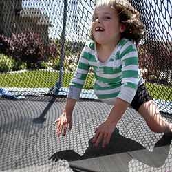 Maliyah Herrin jumps on the trampoline outside of her home. She and Kendra get around with agility and speed without prostheses.