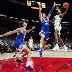 Oregon forward Eric Williams Jr., right, shoots over BYU forward Caleb Lohner, during the first half of an NCAA college basketball game in Portland, Ore., Tuesday, Nov. 16, 2021.