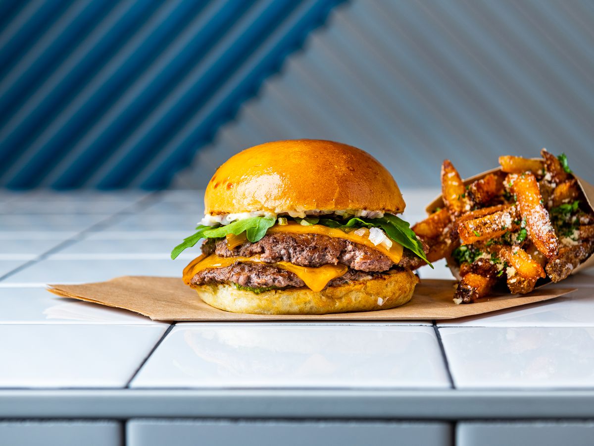 Swizzler’s “Swizz Stack” (grass-fed beef, arugula, dill pickle, stack sauce) and Parmesan truffle fries.