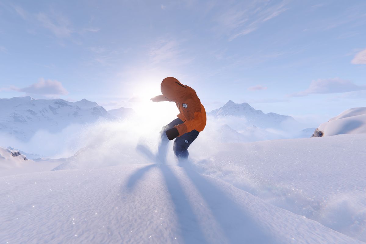 a snowboarder rides down a snowy mountain. 