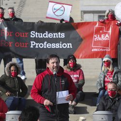 Salt Lake City School District teachers hold signs as they listen to Salt Lake Education Association President James Tobler during a press conference in support of student and educator safety during the COVID-19 pandemic on the steps of the Capitol in Salt Lake City on Wednesday, Feb. 24, 2021. The Salt Lake Education Association held the event to raise awareness of the actions of lawmakers who worked to leverage the Salt Lake City School District with legislation designed to usurp local elected school board authority and punish the school district for choosing remote instruction until teachers were vaccinated or safety metrics were met.