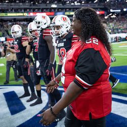 Donna Lowe-Sterns, mother of the late Utah player Aaron Lowe, serves as honorary captain during the coin toss before the Utah Utes play the Oregon Ducks in the Pac-12 championship game at Allegiant Stadium in Las Vegas on Friday, Dec. 3, 2021.