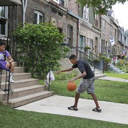 In this Aug. 22, 2014 file photo, Matthew Swalek, left, and Tyler Belisle hang out on the stoop in the Pullman neighborhood of Chicago. President Barack Obama is designating three new national monuments for protection as historic or ecologically significant sites, including the Pullman neighborhood in Chicago where African-American railroad workers won a historic labor agreement.