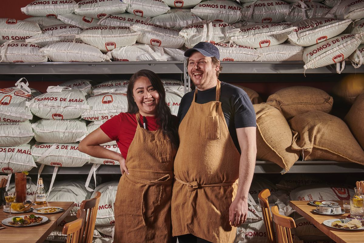 Diana and Zack&nbsp;Wangeman pose for a photo in brown aprons.
