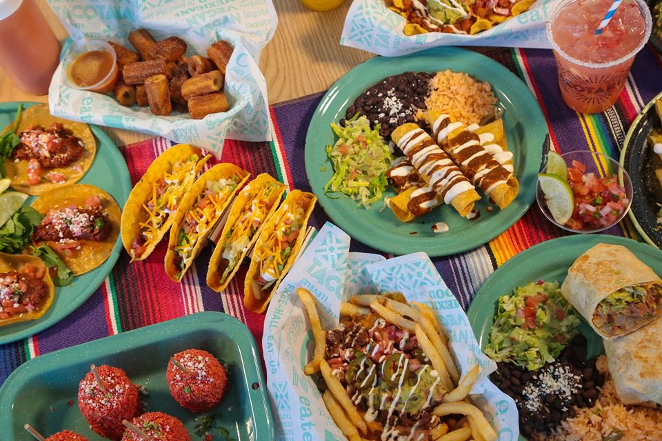 Overhead view of vegan tacos, churros, burritos and beverages
