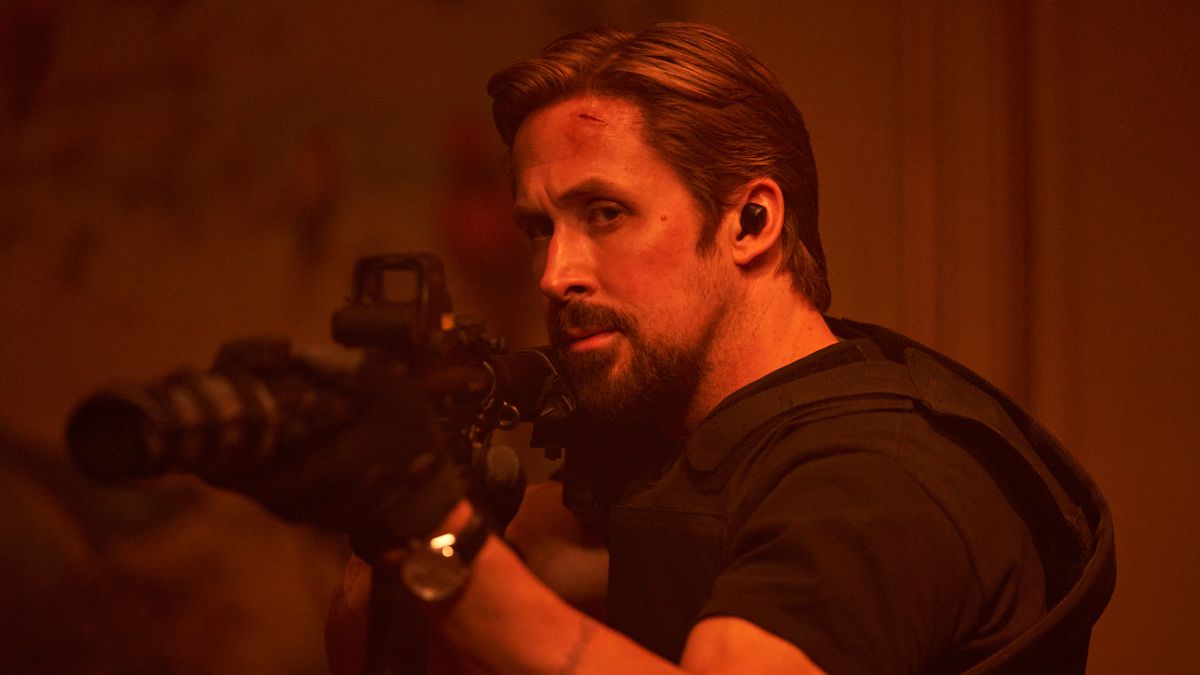 Ryan Gosling wields a tactical assault rifle in body armor in The Gray Man
