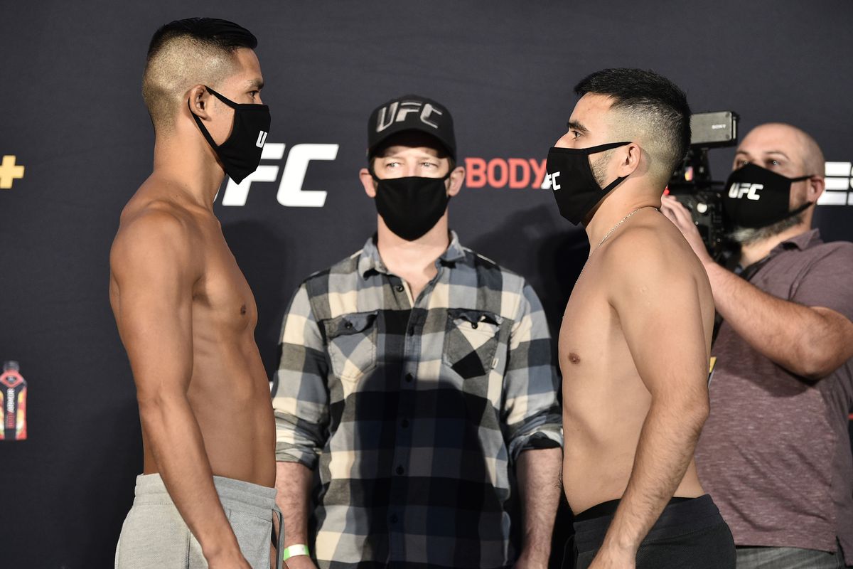 Opponents Tyson Nam and Zarrukh Adashev of Uzbekistan face off during the UFC Fight Night weigh-in at UFC APEX on June 12, 2020 in Las Vegas, Nevada.