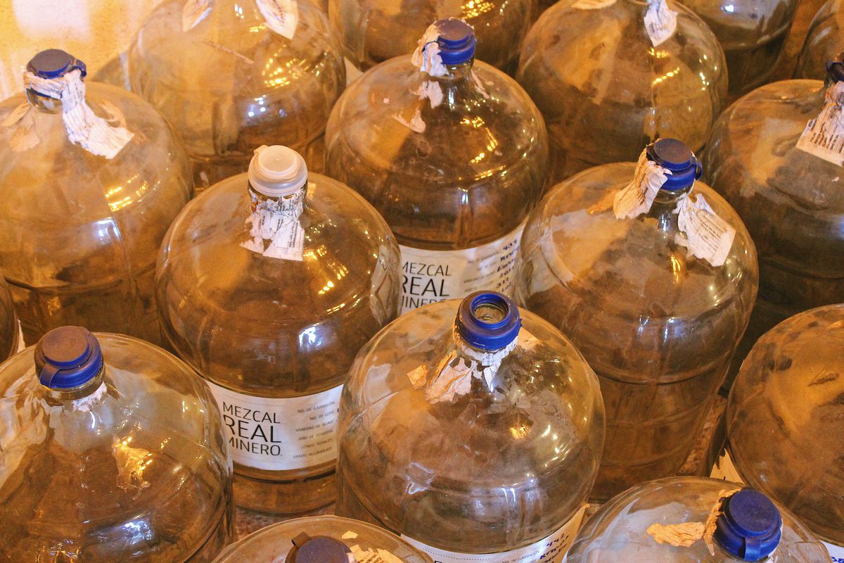 Large jugs of mezcal labeled “Real Minero.” 