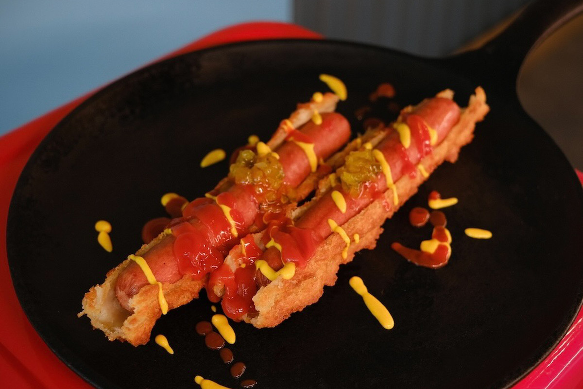 A plate with two churro dogs.