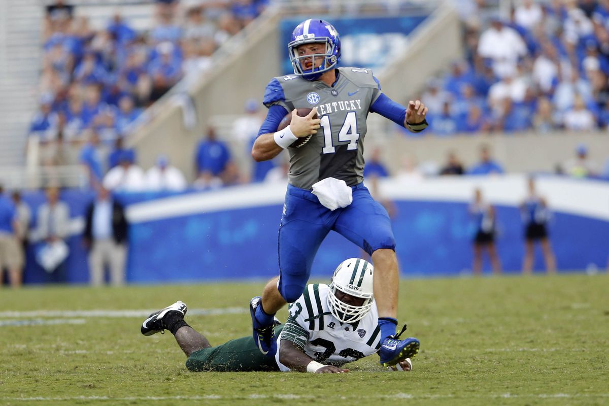  Kentucky Wildcats quarterback Patrick Towles (14) runs from Ohio Bobcats linebacker Quentin Poling (32) during the 2nd half.