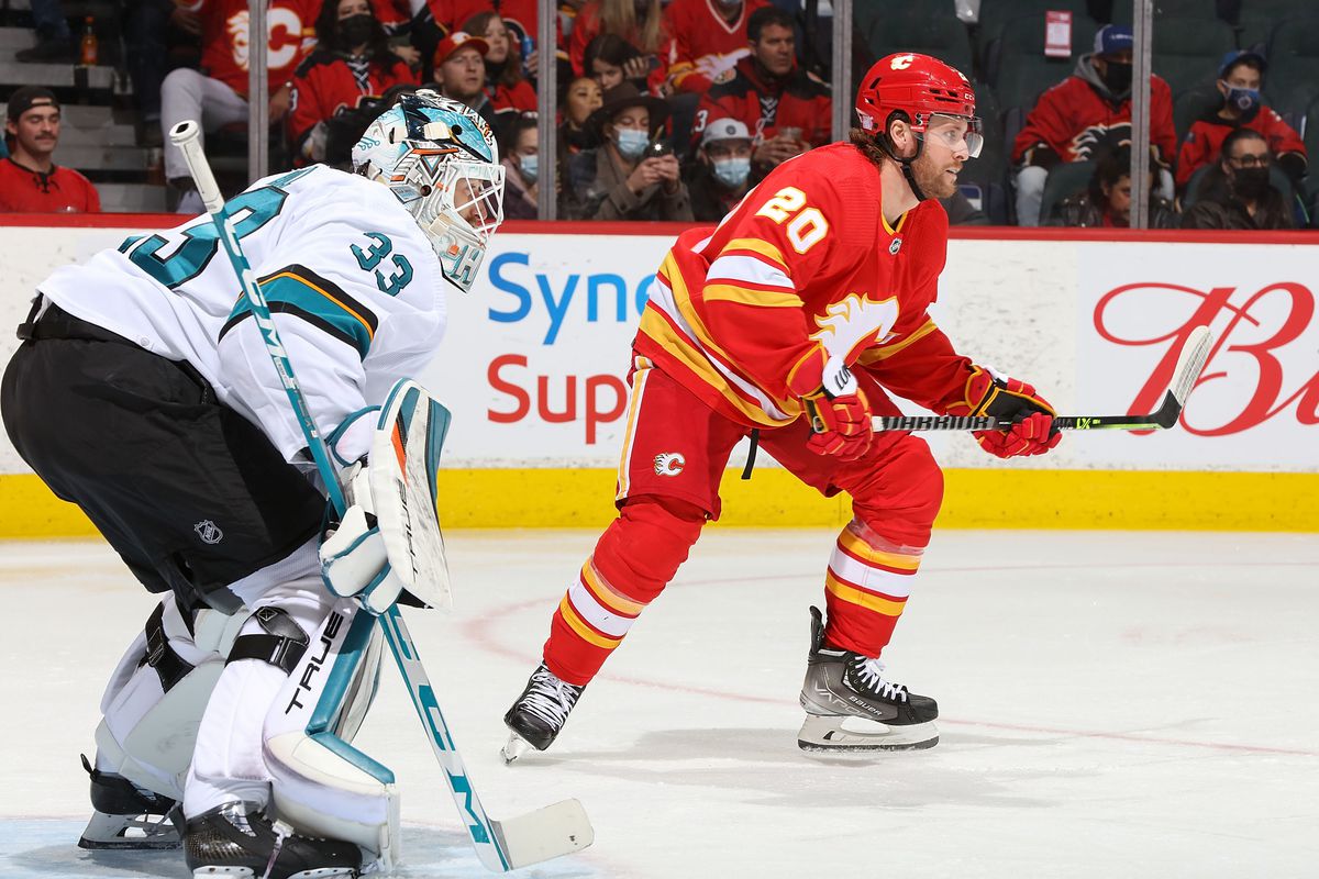 Blake Coleman #20 of the Calgary Flames battles in front of the net against Adin Hill #33 of the San Jose Sharks at Scotiabank Saddledome on November 9, 2021 in Calgary, Alberta, Canada.