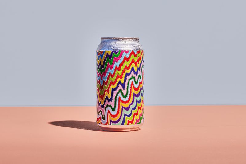Aluminum can with rainbow-colored label design dripping down the sides.
