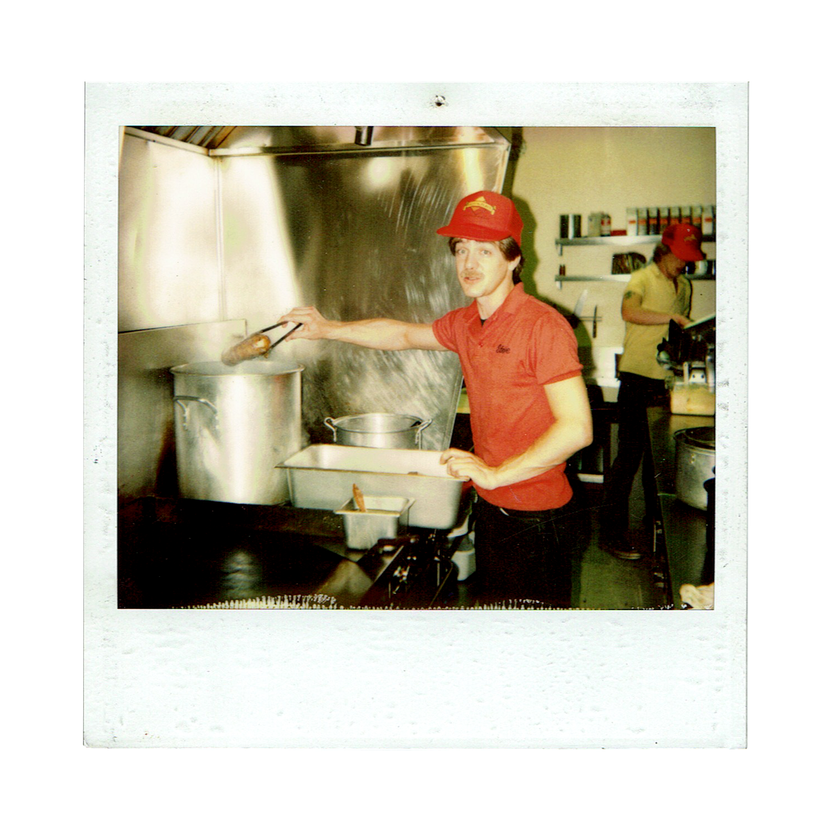 A polaroid of an old photo of a cook in a diner.