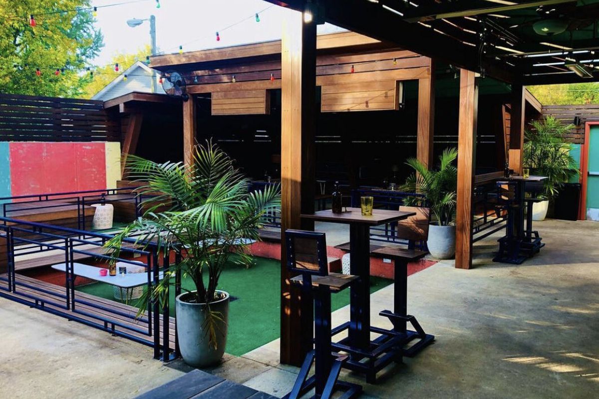 A patio filled with green plants and wood details