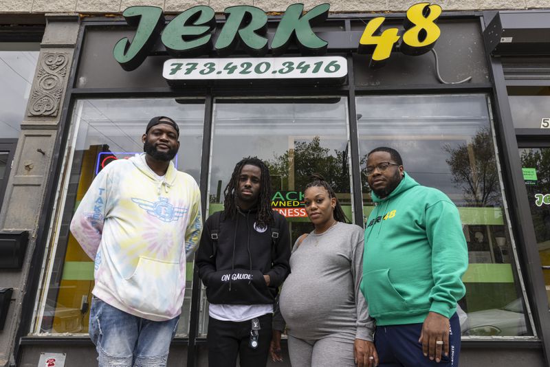 pose for a portrait outside Jerk 48 a restaurant used frequently for Korporate’s skits at 548 E. 67th St. in West Woodlawn