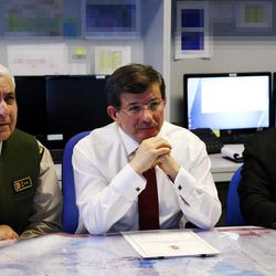 Turkish Prime Minister Ahmet Davutoglu is flanked by Chief of Staff Gen. Necdet Ozel, left, and Defense Minister Ismet Yilmaz as they get a briefing about the military operation in Syria, at the army headquarters in Ankara, Turkey, Sunday, Feb. 22, 2015. Turkey launched an overnight military operation into neighboring Syria to evacuate troops guarding an Ottoman tomb and to move the crypt to a new location, Davutoglu said Sunday. Davutoglu said nearly 600 troops and 100 tanks and armored personnel carriers were involved in the operation. One group crossed into Syrian territory to reach the tomb, just over the border near the town of Kobani, while a second group took control of an area near the Turkish border where authorities plan to move the tomb.
