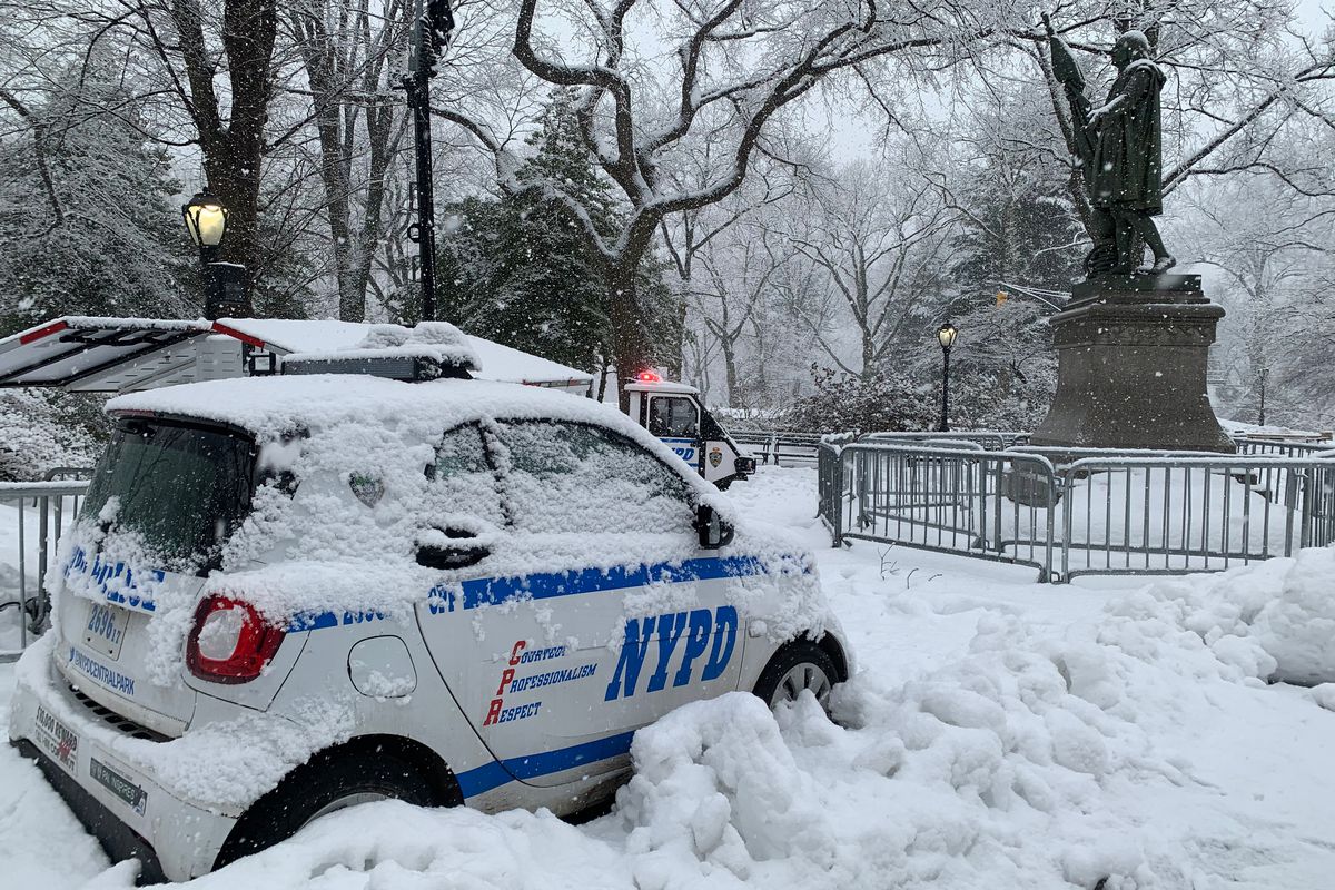 Multiple NYPD officers guard a statue of Christopher Columbus in Central Park during a snowstorm, Feb. 7, 2021.