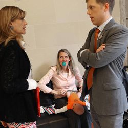 Tenille Farr holds a pacifier in her mouth while changing her newborn son as Christine Stenquist and Connor Boyack, president of Libertas Institute, plan which senators to speak with while lobbying for the legalization of medical cannabis at the Capitol on Wednesday, Feb. 25, 2015. 
