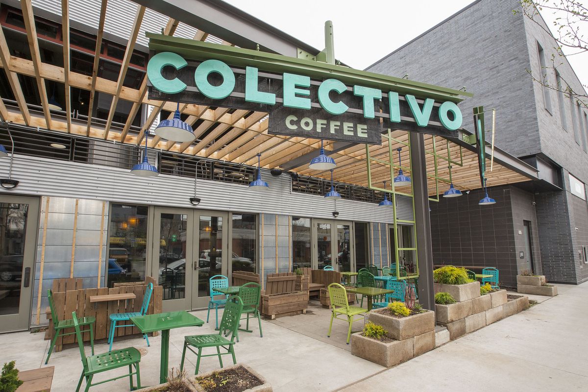 Outdoor seating beside a large, industrial-style cafe with a large teal sign that reads “Colectivo Coffee”