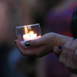 Friends of the Castillo family hold candles during the vigil for Kay Castillo, a deceased mother of three, at their home on Monday, June 9, 2014, in Layton. 