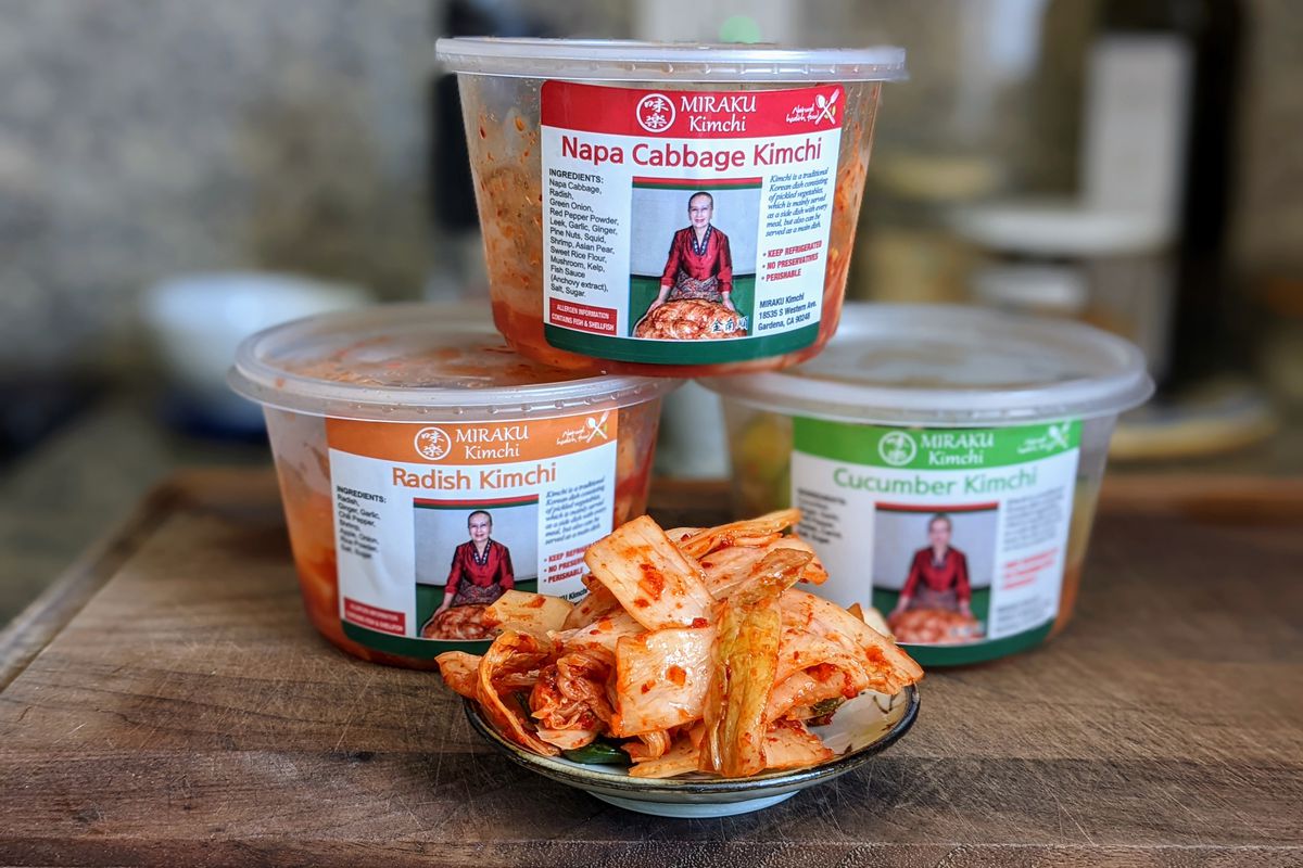 Bins of kimchi with some on a small plate.