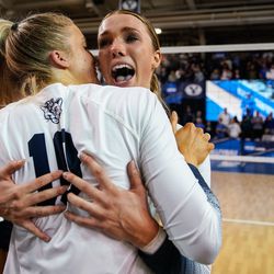 BYU’s Kenzie Koerber, back and Erin Livingston embraces each other after winning against Utah in an NCAA volleyball game at Smith Fieldhouse in Provo on Saturday, Dec. 4, 2021.