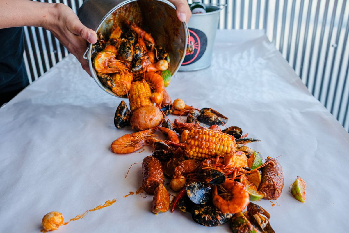 A bucket of sauced shrimp, mussels, crawfish, sausage and corn on the Crab N Spice menu headed to Chinatown.