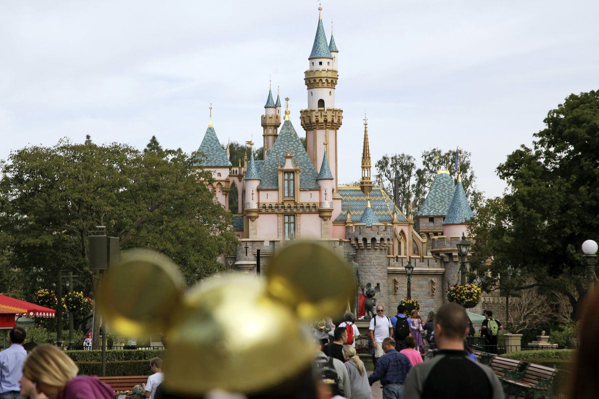 In this Jan. 22, 2015, file photo, visitors walk toward Sleeping Beauty's Castle in the background at Disneyland Resort in Anaheim, Calif. Disney will soon remove all smoking areas from within its parks, according to the Orlando Sentinel.