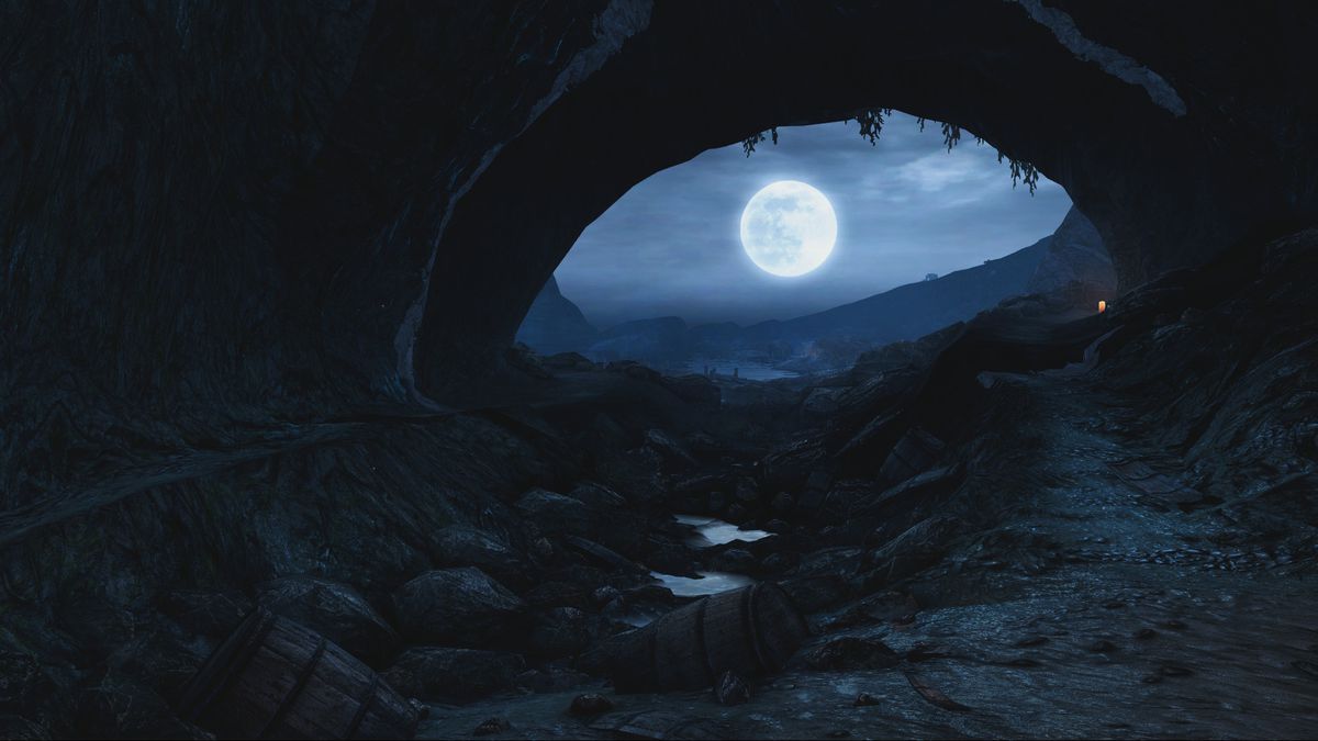 A cave entrance and the moon together form an eye in Dear Esther: Landmark Edition. Broken barrels and other detritus line the foreground.