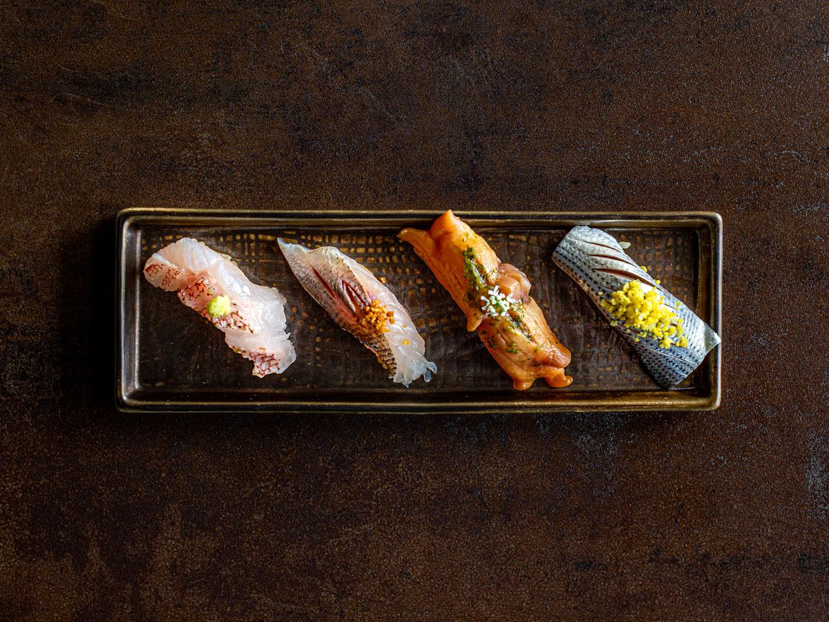 Four pieces of nigiri on a plate at Hidden Omakase.