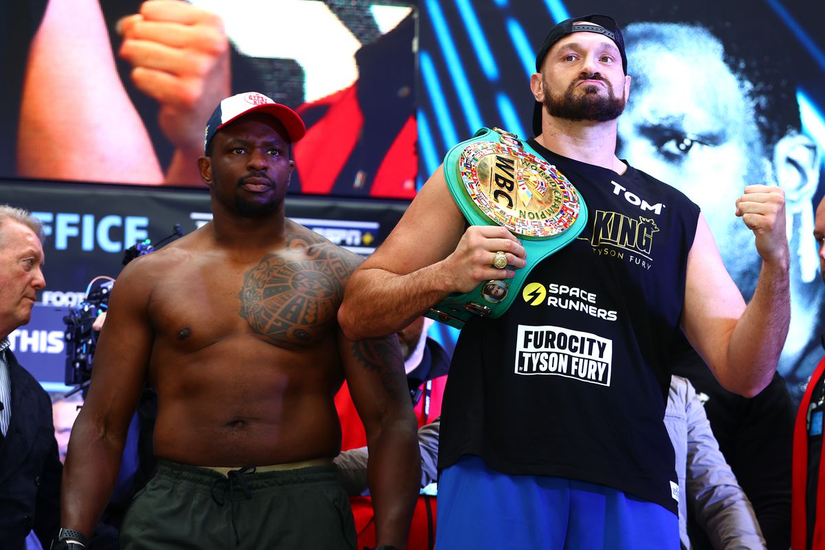 Dillian Whyte (L) and Tyson Fury (R) pose during the weigh in prior to their WBC heavyweight championship fight at BOXPARK on April 22, 2022 in London, England.