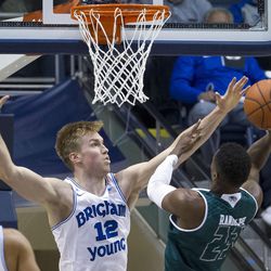 Brigham Young forward Eric Mika (12) tries to block a shot by Utah Valley guard Brandon Randolph (23) during an NCAA college basketball game in Provo on Saturday, Nov. 26, 2016. Utah Valley was 18 of 37 from beyond the arc en route to a 114-101 ousting of Brigham Young.